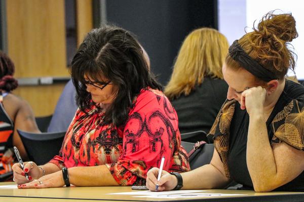 two people concentrating on writing